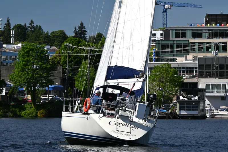 Slide: The Image of Sailboat C&C 37/40+ (1989) navigating urban waters with lush greenery and buildings. - 44
