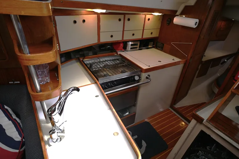 Slide: The Image of 1989 C&C 37/40+ yacht interior kitchen with stove, sink, and wooden cabinetry. - 9