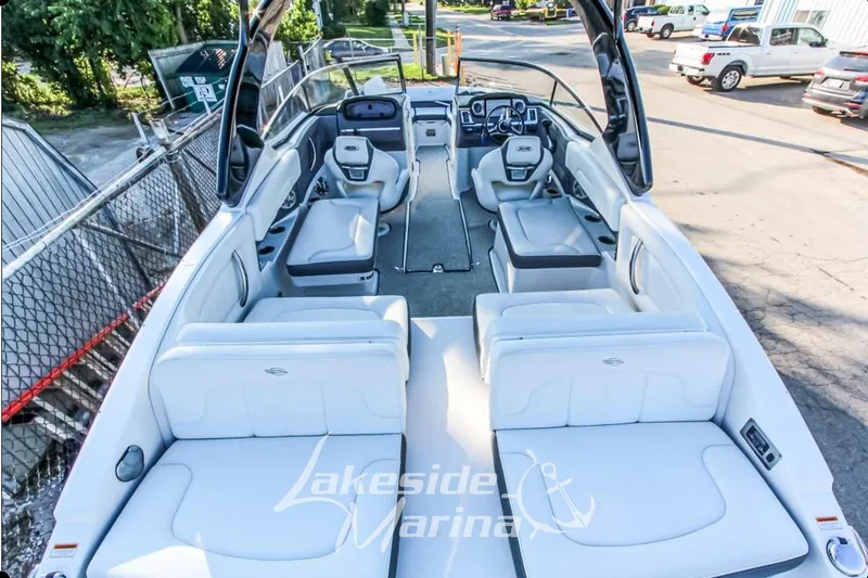 Slide: The Image of 2013 Chaparral 257 SSX boat interior with white seating, parked at marina. - 5