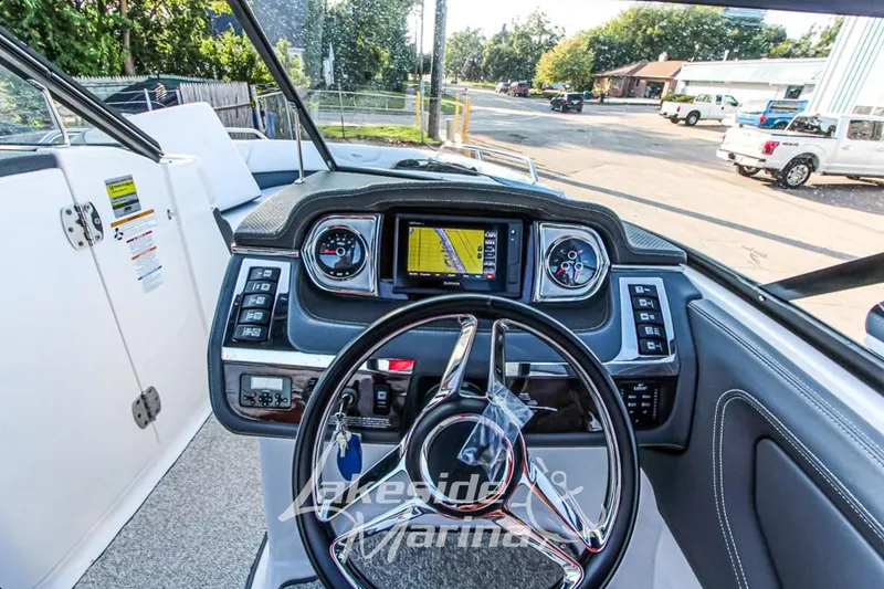 Slide: The Image of 2013 Chaparral 257 SSX boat dashboard with steering wheel and navigation display. - 8