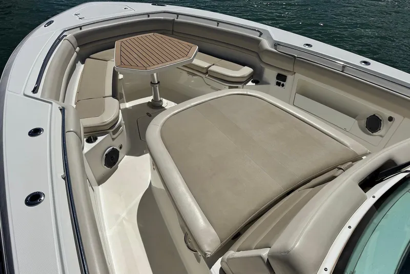 Slide: The Image of 2019 Boston Whaler 380 Outrage boat interior with cushioned seating and table. - 11