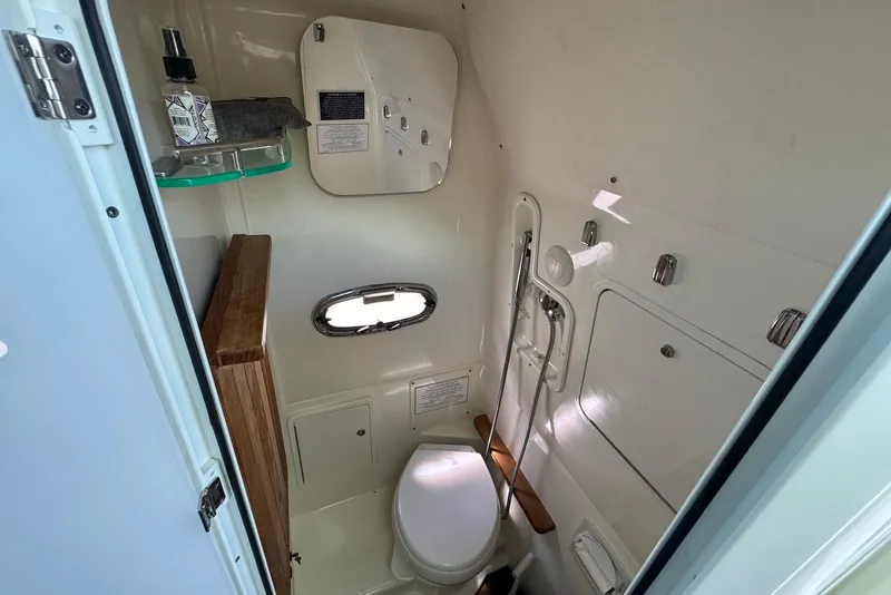 Slide: The Image of 2019 Boston Whaler 380 Outrage boat bathroom interior with toilet and storage. - 19