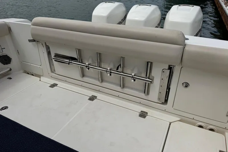 Slide: The Image of 2019 Boston Whaler 380 Outrage boat deck with rod holders and triple engines. - 23