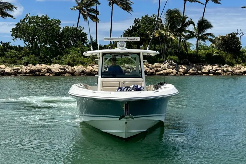 Slide: The Image of 2019 Boston Whaler 380 Outrage boat cruising in tropical waters with palm trees. - 3