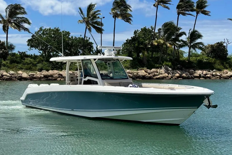 Slide: The Image of 2019 Boston Whaler 380 Outrage boat cruising on tropical waters with palm trees. - 4
