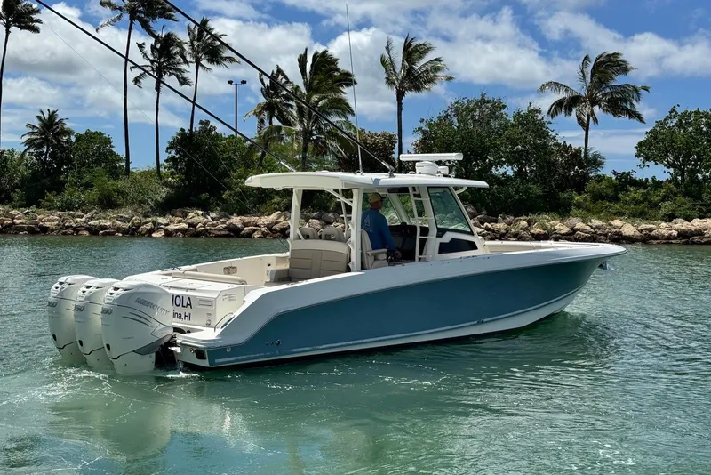 Slide: The Image of 2019 Boston Whaler 380 Outrage boat cruising in tropical waters with palm trees in background. - 6