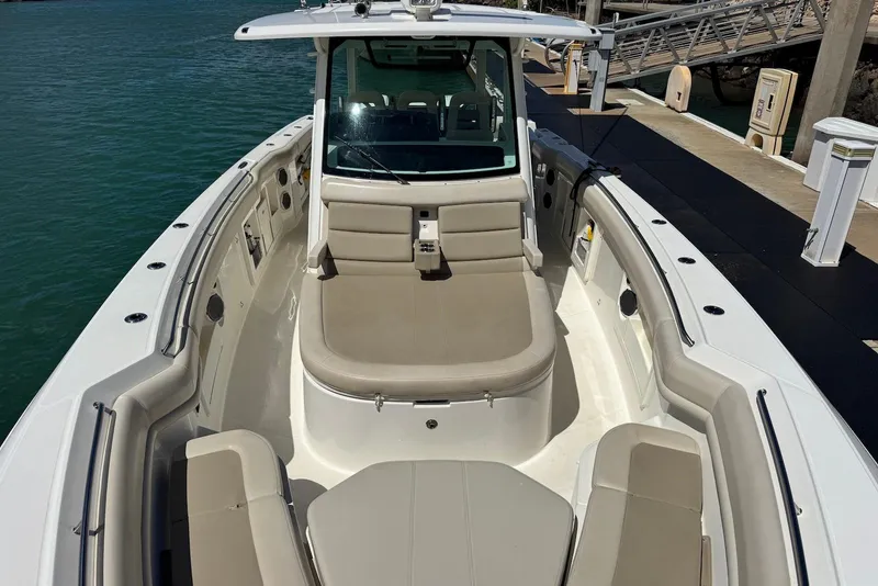 Slide: The Image of 2019 Boston Whaler 380 Outrage boat docked, featuring spacious seating and sleek design. - 8