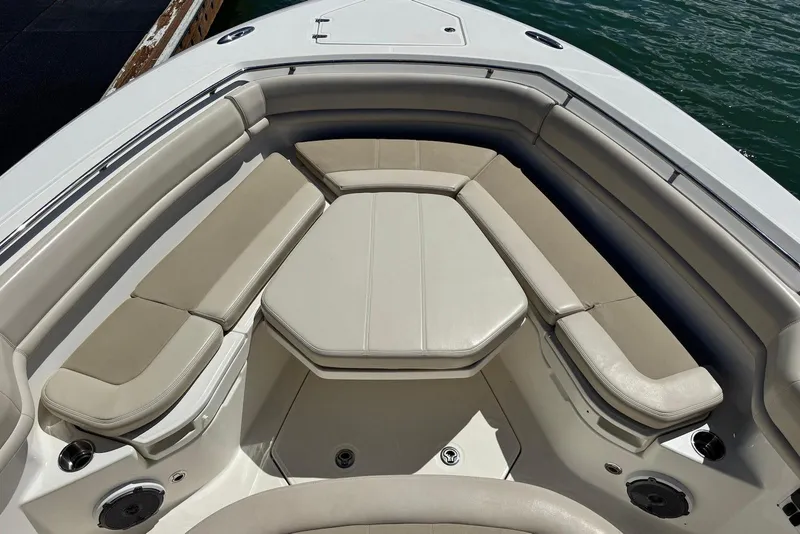 Slide: The Image of 2019 Boston Whaler 380 Outrage boat interior with cushioned seating and cup holders. - 9