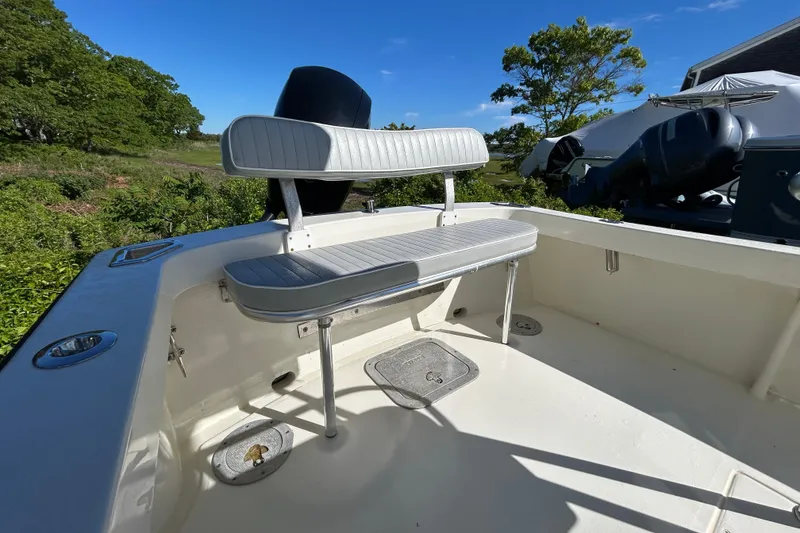 Slide: The Image of 2004 Gloucester G-20 boat interior with white seating and lush greenery background. - 12