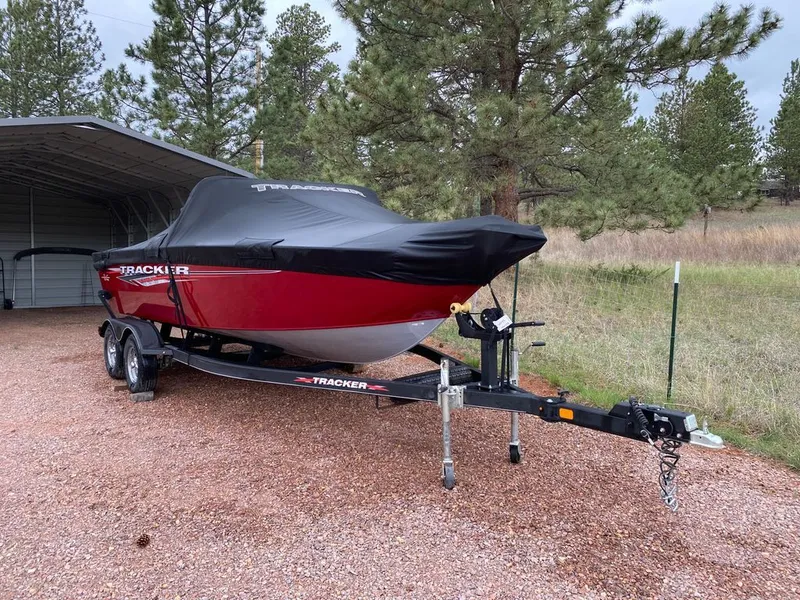 Slide: The Image of 2021 Tracker Pro Guide boat with cover on trailer outdoors. - 2
