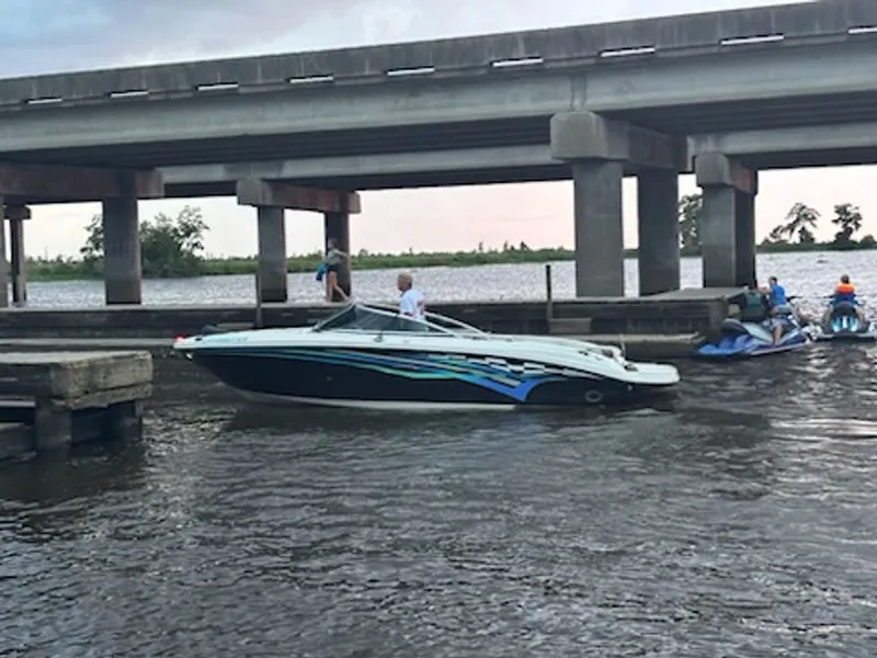 Slide: The Image of 2006 Sea Ray 220 Select boat under bridge on water. - 2
