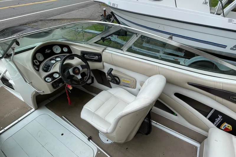 Slide: The Image of Interior of a 2000 Mariah 202 Shabah boat, featuring steering wheel and dashboard controls. - 10
