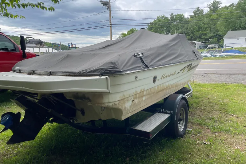 Slide: The Image of Covered 2000 Mariah 202 Shabah boat on trailer, parked outdoors near road. - 3