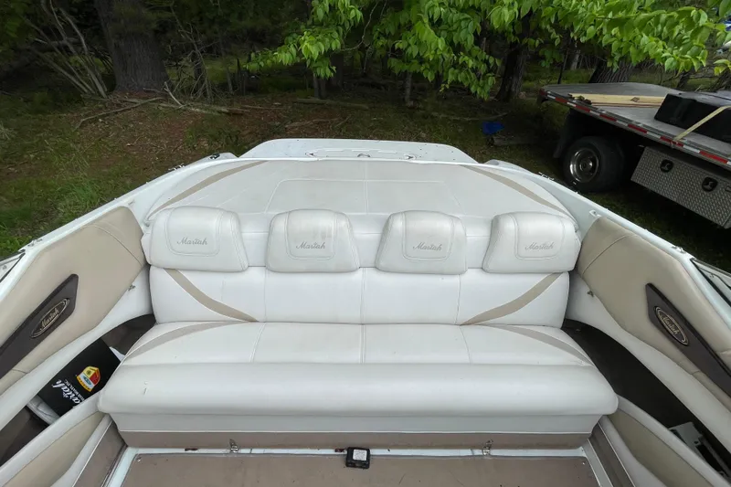 Slide: The Image of White leather seating in a 2000 Mariah 202 Shabah boat, surrounded by greenery. - 8