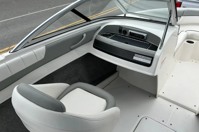 Slide: The Image of 2013 Bayliner 195 Bowrider interior with gray and white seating and dashboard. - 7