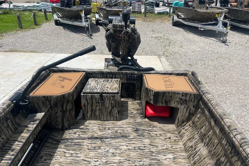 Slide: The Image of 2026 Excel 1854 F4 Pro boat with camouflage design, parked on gravel. - 12