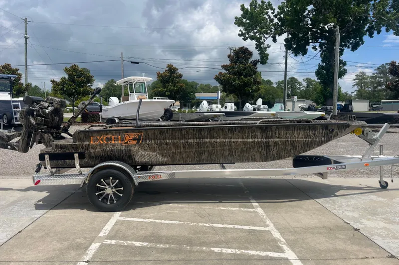 Slide: The Image of 2026 Excel 1854 F4 Pro boat on trailer, parked outdoors under cloudy sky. - 5