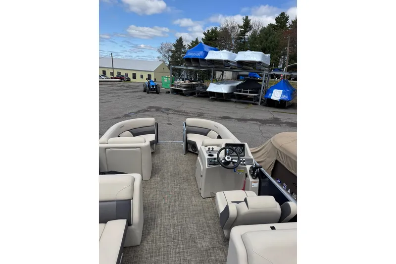The Image of 2023 Harris Cruiser 210 CW pontoon boat interior with beige seating and steering console. - 1