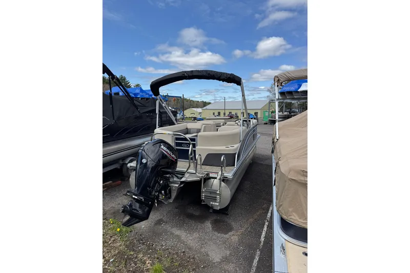 Slide: The Image of 2023 Harris Cruiser 210 CW pontoon boat with Mercury outboard motor, parked outdoors. - 4