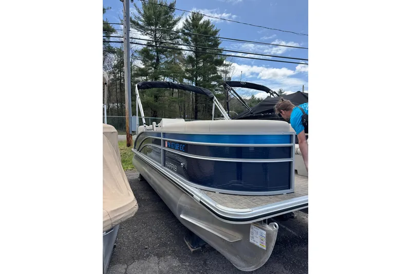 Slide: The Image of 2023 Harris Cruiser 210 CW pontoon boat parked outdoors on a sunny day. - 9