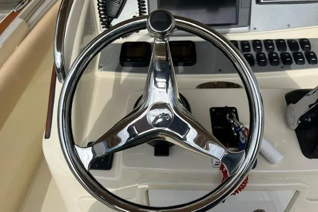 Slide: The Image of Steering wheel of a 2015 Chris-Craft Catalina 23 boat, featuring a sleek chrome design. - 15