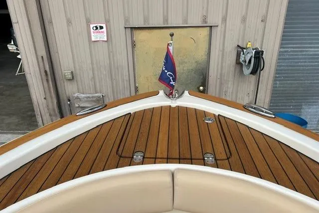 Slide: The Image of 2015 Chris-Craft Catalina 23 boat with teak deck and flag, docked near a building. - 21