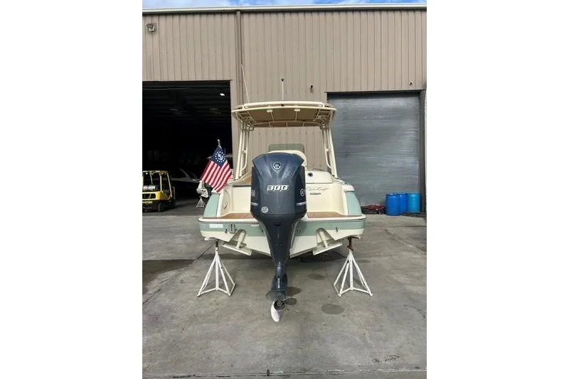 Slide: The Image of 2015 Chris-Craft Catalina 23 boat with outboard motor, parked near a warehouse. - 3