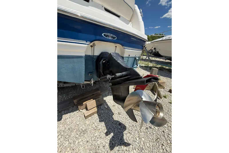 Slide: The Image of 2000 Chaparral Signature 240 boat stern with propeller, parked on gravel. - 11