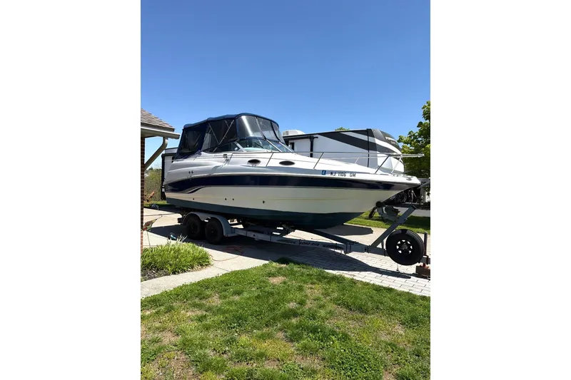 Slide: The Image of 2000 Chaparral Signature 240 boat on trailer, parked outdoors under clear blue sky. - 2