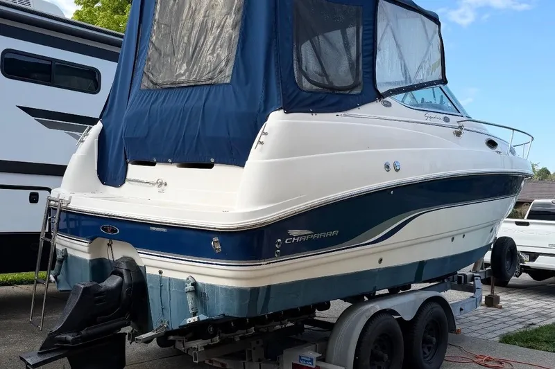 Slide: The Image of 2000 Chaparral Signature 240 boat on trailer with blue cover, parked outdoors. - 3