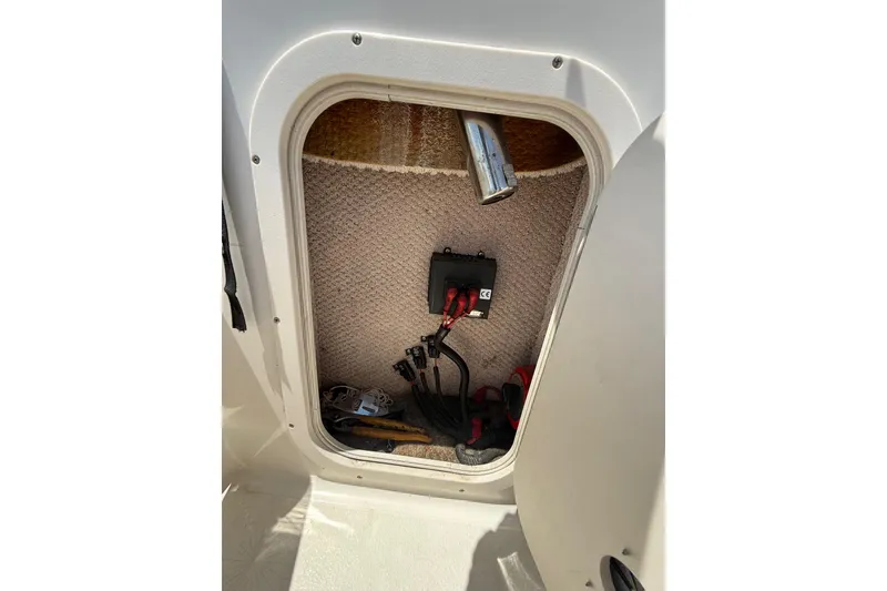 Slide: The Image of Storage compartment in a 2000 Chaparral Signature 240 boat, showing cables and tools. - 30