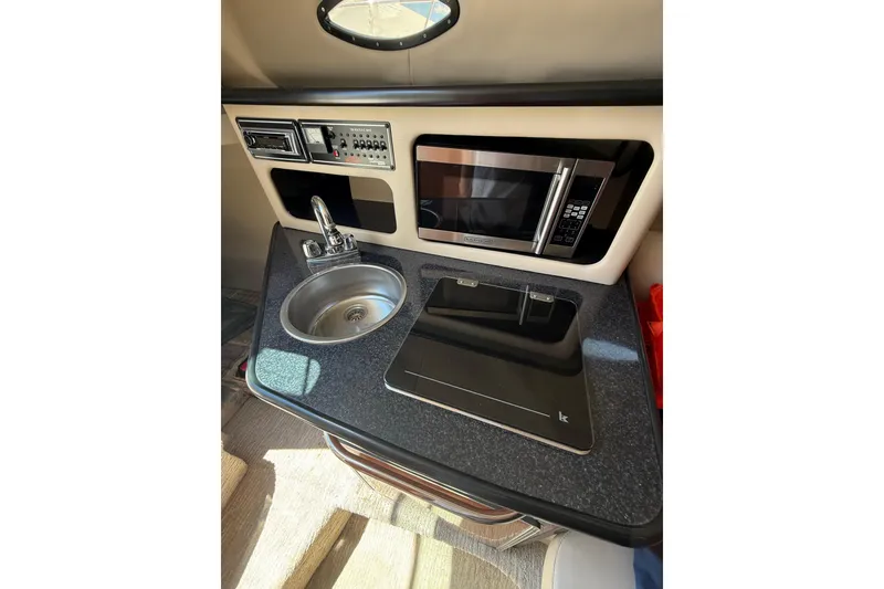 Slide: The Image of Compact kitchenette in 2000 Chaparral Signature 240 boat with sink, microwave, and stove. - 33