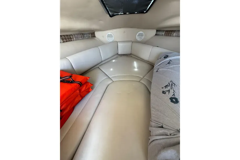 Slide: The Image of Interior cabin of 2000 Chaparral Signature 240 boat with beige seating and life jackets. - 34