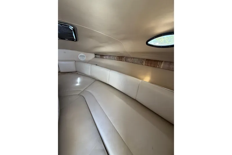 Slide: The Image of Interior cabin of 2000 Chaparral Signature 240 boat, featuring beige seating and oval window. - 37