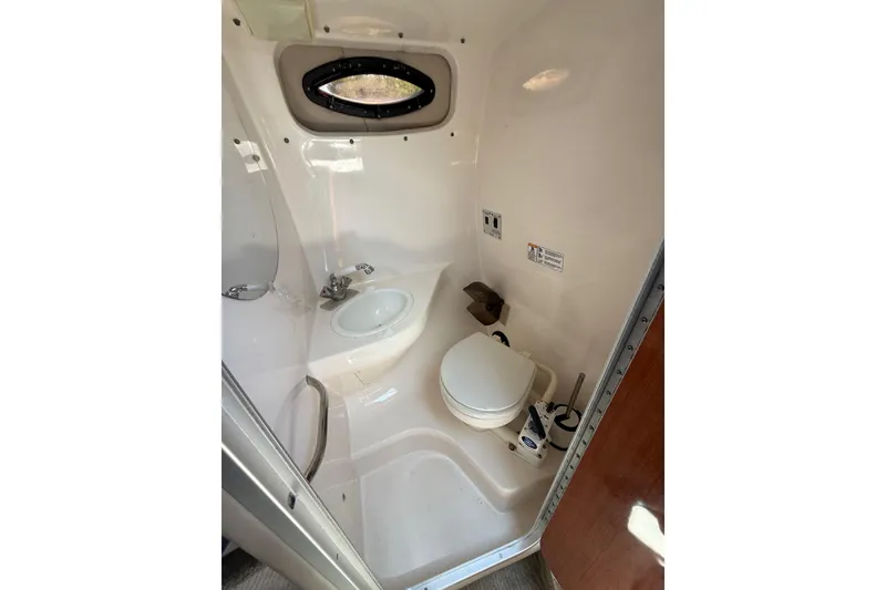 Slide: The Image of Compact bathroom in 2000 Chaparral Signature 240 boat, featuring toilet and sink. - 39