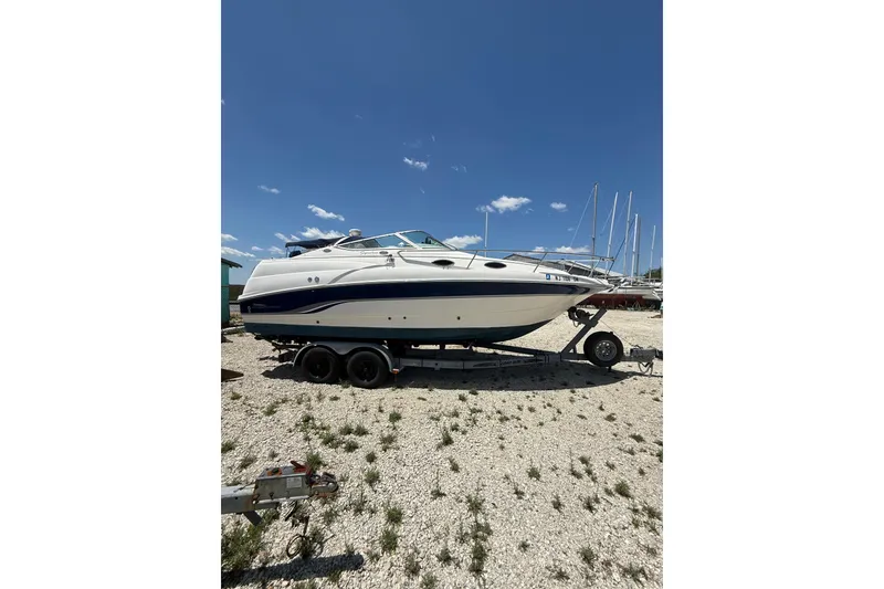 Slide: The Image of Chaparral Signature 240 boat from 2000 on a trailer under a clear blue sky. - 4