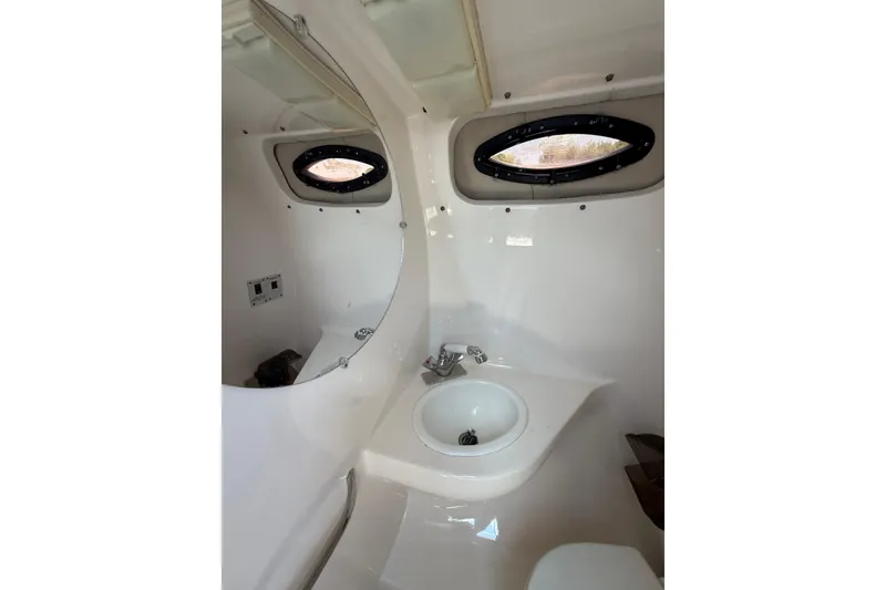 Slide: The Image of Interior of 2000 Chaparral Signature 240 boat bathroom with sink and porthole windows. - 40