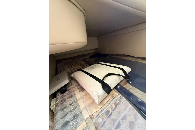Slide: The Image of Interior cabin view of a 2000 Chaparral Signature 240 boat, featuring a cozy sleeping area. - 43