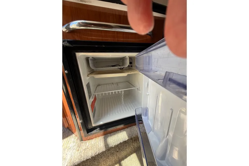 Slide: The Image of Open refrigerator inside a 2000 Chaparral Signature 240 boat cabin. - 44