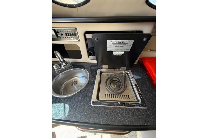 Slide: The Image of 2000 Chaparral Signature 240 boat kitchenette with sink and stove. - 45