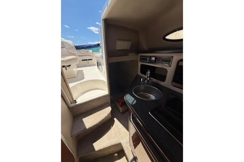 Slide: The Image of Interior view of 2000 Chaparral Signature 240 boat, featuring compact kitchenette and seating area. - 49