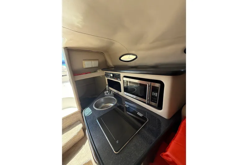 Slide: The Image of 2000 Chaparral Signature 240 boat interior with kitchenette, featuring sink and microwave. - 50
