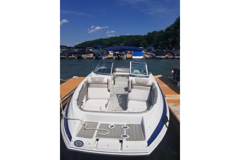 Slide: The Image of 2022 Crownline Eclipse E255 boat docked at a marina under a clear blue sky. - 19