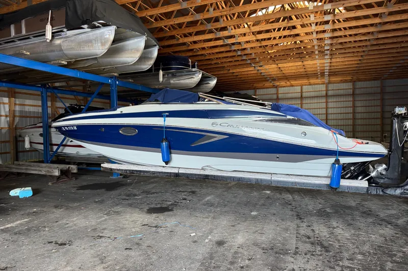 Slide: The Image of 2022 Crownline Eclipse E255 boat stored in a wooden boathouse. - 20