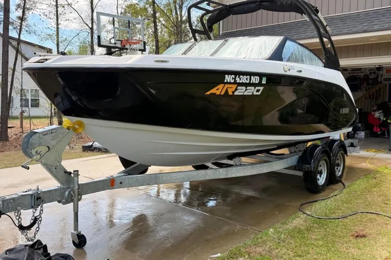 Slide: The Image of 2024 Yamaha Boats AR220 on trailer, parked in driveway near garage. - 3