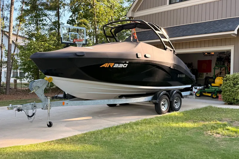 Slide: The Image of 2024 Yamaha Boats AR220 on trailer in driveway, covered and ready for transport. - 5