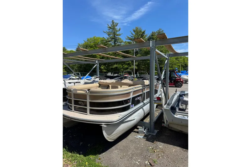 The Image of 2012 Harris FloteBote Sunliner 220 pontoon boat under metal canopy, parked outdoors. - 0