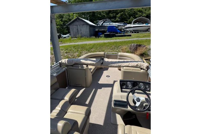Slide: The Image of 2012 Harris FloteBote Sunliner 220 pontoon boat interior with beige seating and steering console. - 3