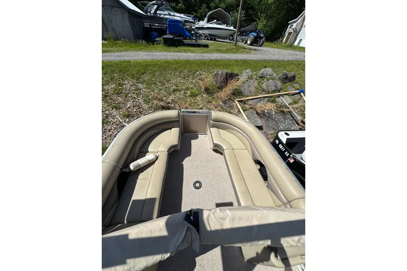 Slide: The Image of 2012 Harris FloteBote Sunliner 220 pontoon boat with beige seating, parked outdoors. - 5