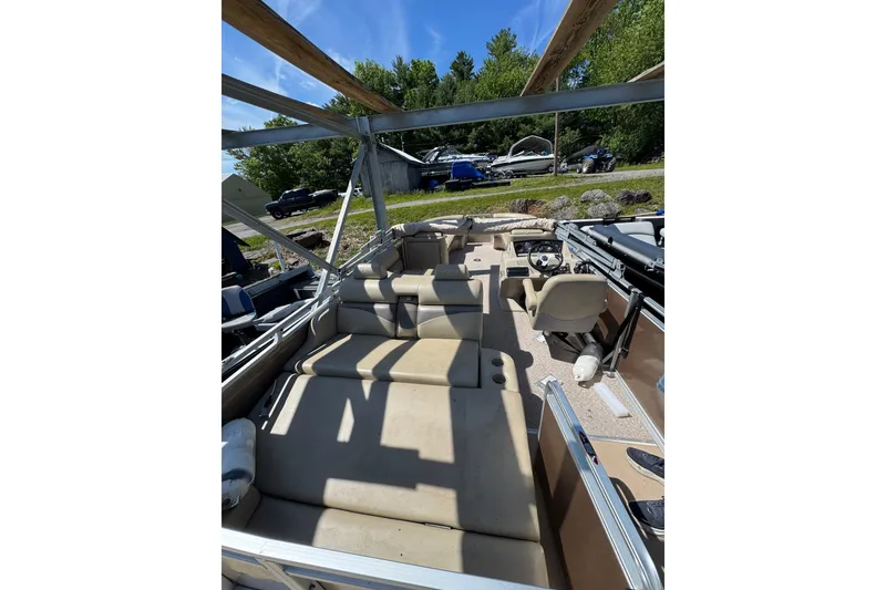 Slide: The Image of 2012 Harris FloteBote Sunliner 220 pontoon boat interior with beige seating and steering console. - 7